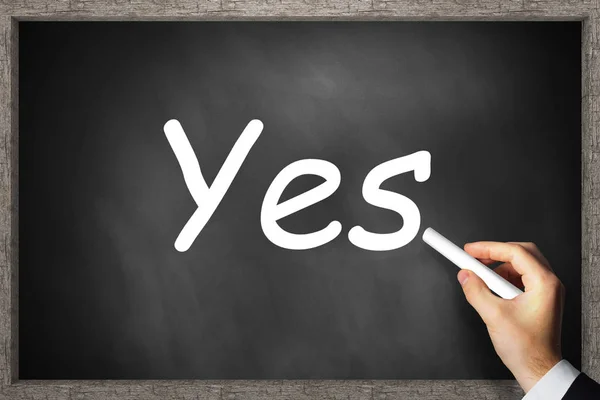 Hand writing yes on black chalkboard — Stock Photo, Image