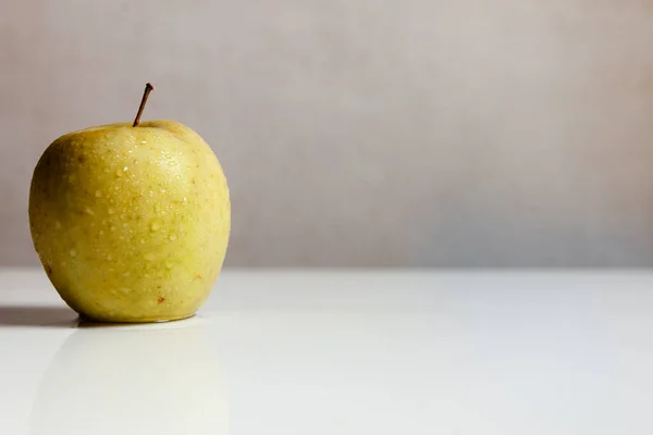 Beyaz bir masada yeşil elma