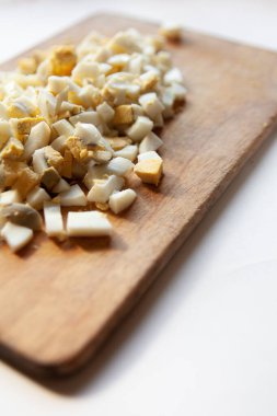 Kaynamış yumurta, beyaz bir masada küp şeklinde kesilmiş.