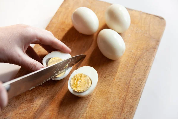 Kesme tahtasındaki yumurtayı kes.