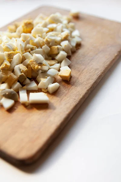 Kaynamış yumurta, beyaz bir masada küp şeklinde kesilmiş.