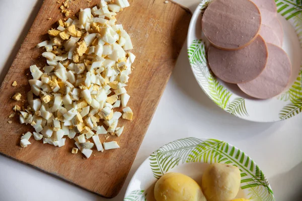 Haşlanmış yumurta, haşlanmış patates, beyaz masada haşlanmış sosis.