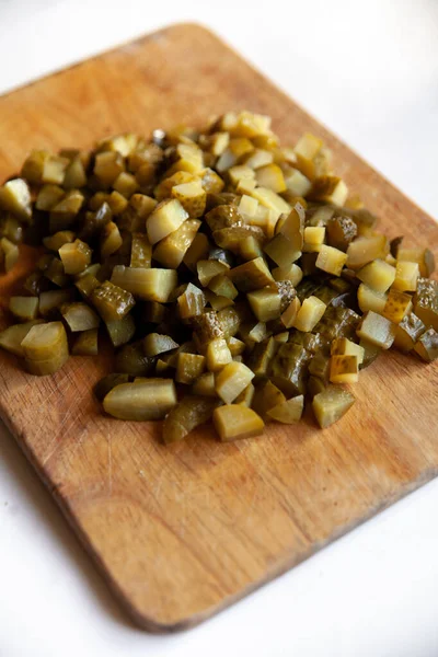 Beyaz bir masada dilimlenmiş turşu.