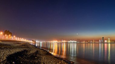 Sea Beach 'ten Aydınlanmış Şehir Manzarası' na güzel bir gece manzarası. Batumi, Adjara, Gürcistan 'da Karadeniz' deki ışıkların yansımaları.