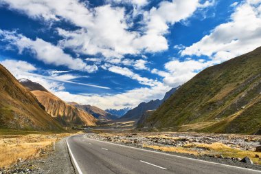 Kafkas dağları, asfalt yol, bulutlu gökyüzü, askeri yol Gürcistan manzaralı güzel bir manzara..