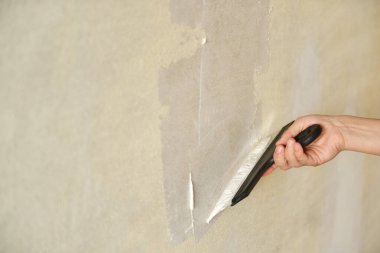 Usta işçi duvarlara alçı yapıştırıyor. Elinde macunla Spatula. Tamir işleri. Alçılama duvarı.