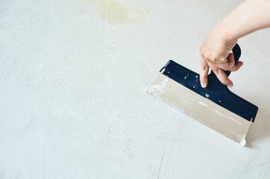 Elinde macunla Spatula. İşçi duvara alçı yapıştırıyor. Tamir işleri, dekorasyon bina konsepti, inşaat..