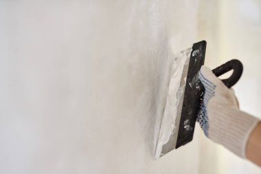 Elinde macunla Spatula. İşçi duvara alçı yapıştırıyor. Tamir işleri, dekorasyon bina konsepti, inşaat..