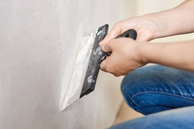 Ellerinde macunla Spatula. İşçi duvara alçı yapıştırıyor. Tamir işleri, dekorasyon bina konsepti, inşaat..
