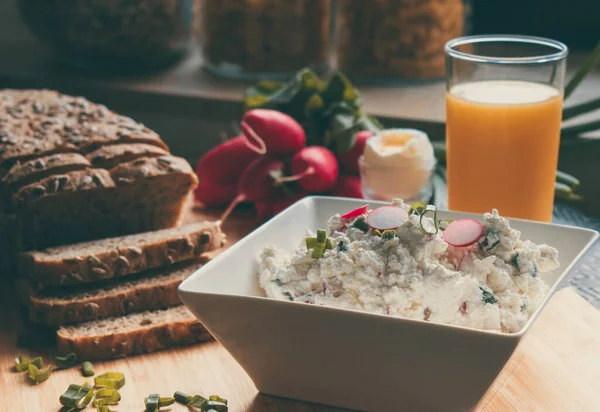 Turplu beyaz süzme peynir, soğan. Haşlanmış yumurta, ev yapımı ekmek ve portakal suyu.