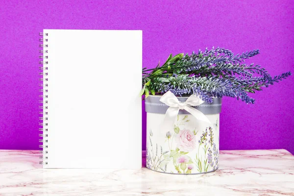 Blank notebook with lavender flowers and floral box on a purple background