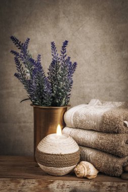 Kaplıca malzemeleri, aroma çubukları, taşlar, havlular, ahşap bir arka planda deniz kabuğu.