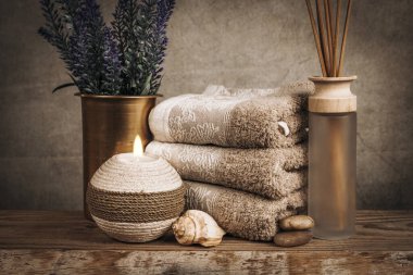 Kaplıca malzemeleri, aroma çubukları, taşlar, havlular, ahşap bir arka planda deniz kabuğu.