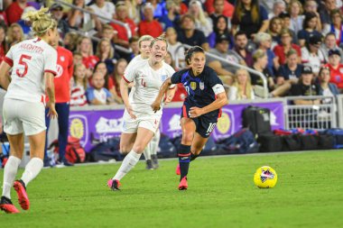 USWNT oyuncusu Carli Lloyd # 10 koşu, 5 Mart 2020 tarihinde Orlando Florida 'daki Exploria Stadyumu' nda düzenlenen 2020 SheBelieves Kupası sırasında İngiliz oyuncuların yanından geçer. Fotoğraf: Marty Jean-Louis