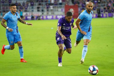 Orlando City 'den Ruan (2), 10 Temmuz Çarşamba günü Floria' nın Orlando kentindeki Exploria Stadyumu 'nda oynanan Amerika Açık Kupası' nda NYC FC defans oyuncularını geçiyor: Marty Jean-Louis