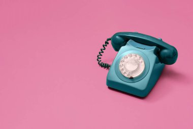 Pembe arka planda antika yeşil döner telefon. Fotokopi alanı ve sağ tarafta kompozisyon olan metin için yer var.