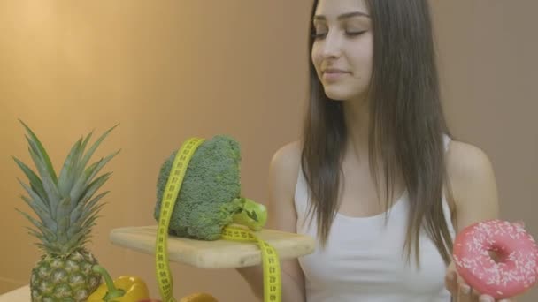 Hermosa chica trae brócoli y pan de jengibre a la cámara — Vídeo de stock