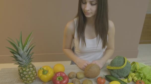 Niña sentada en la mesa elige verduras y frutas para una alimentación saludable — Vídeos de Stock