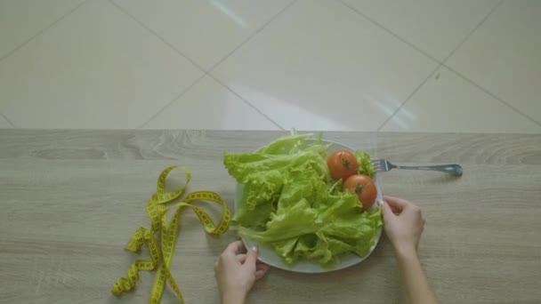 Mulher senta-se em uma mesa e pega seus vegetais — Vídeo de Stock