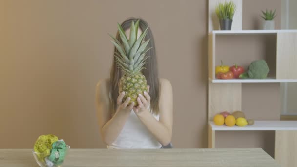 Hermosa mujer en la cámara muestra la piña como una forma de comer sano — Vídeos de Stock