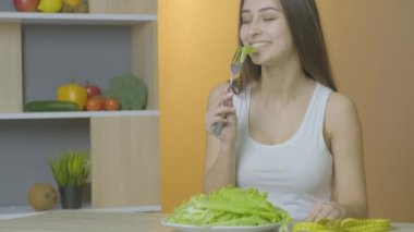 Kafkas görünümlü bir kadın masaya oturur ve lahana yaprakları yer, diyete yapışır.