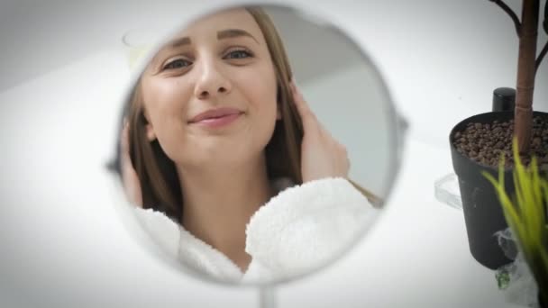 Retrato de una linda mujer con la piel bien arreglada mirando en el espejo — Vídeos de Stock