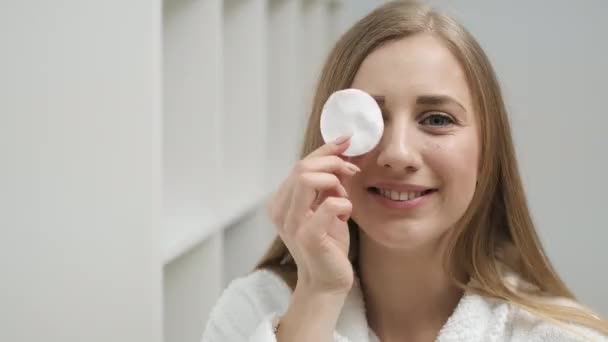 Retrato de una linda mujer con la piel bien arreglada posando en la cámara con una esponja en una habitación luminosa — Vídeo de stock