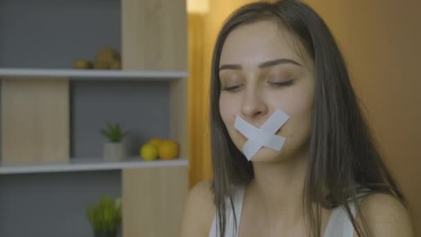 Caucasienne fille regarde tenant un hamburger avec une bouche fermée — Video
