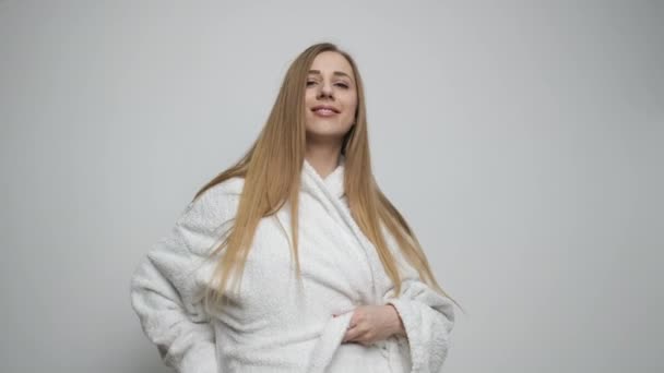 Beautiful girl ties a bathrobe after a bath — Stock Video