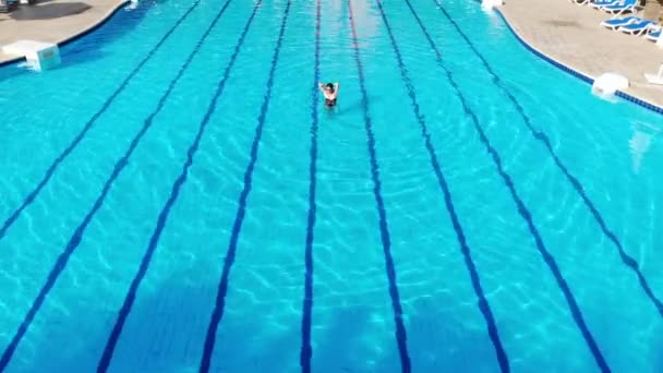 Dron přeletí nad bazénem v Egyptě, kde žena plave na matraci — Stock video