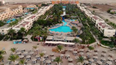 İnsansız hava aracı Mısır 'da güzel bir havuz ve palmiye ağaçları üzerinde uçuyor.