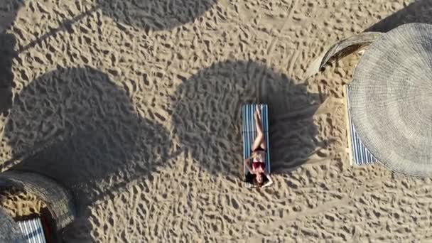 Mooie vrouw ligt op een zonnebank en geniet van de zee. Drone vlucht — Stockvideo