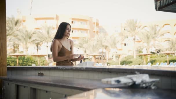 Chica se sienta en un bar en el mar y lleva gafas — Vídeos de Stock