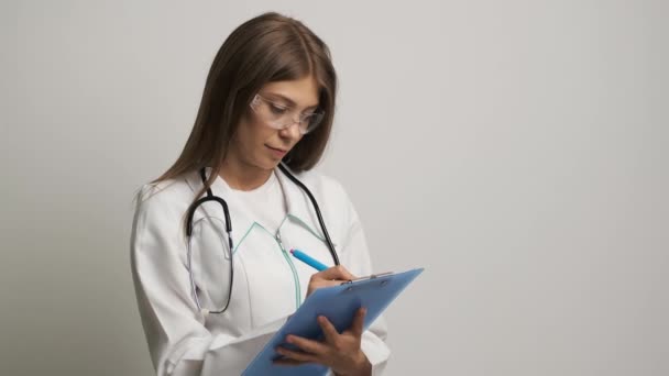 Femmes médecin d'apparence caucasienne écrit sur papier un 4. Médecine. Santé — Video