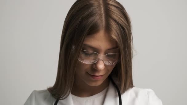 Mulheres bonitas médico de aparência caucasiana sorri para a câmera e mantém um estetoscópio. Saúde — Vídeo de Stock