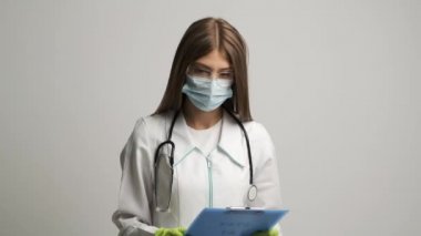 Doktor, üzerinde yazı olan bir klasör gösteriyor. Evde kal.
