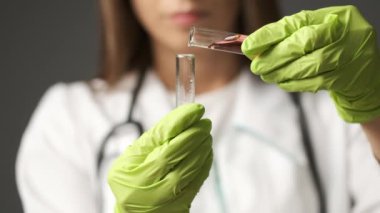 Yeşil eldivenli Kafkas görünümlü kız doktor test tüpleri tutuyor. Sağlık, Tıp