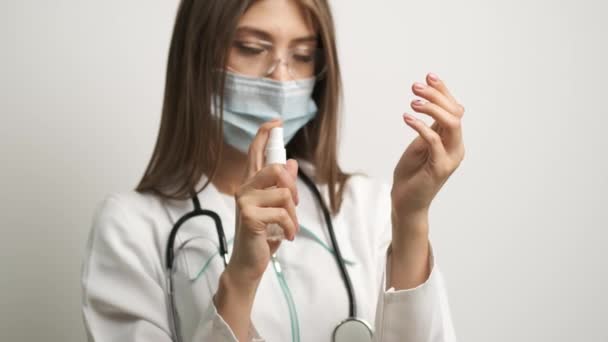Lekarz w goglach Biała dziewczyna trzyma antyseptyk w rękach i kładzie na rękach — Wideo stockowe