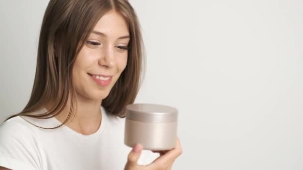 Ragazza apre crema a portata di mano in camere luminose — Video Stock