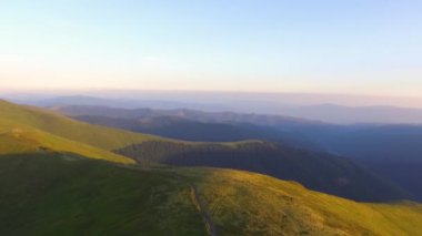 Ukrayna Karpatları üzerinde İHA uçuşu. Güneşli bir yaz gününde dağlar. Gezegenin güzel şehirlerinde genç bir çift