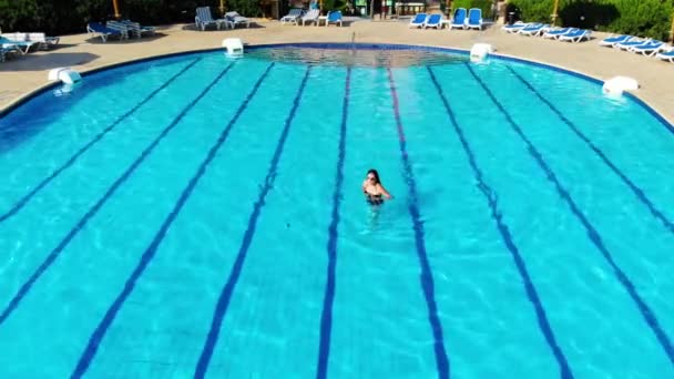 Hermosas mujeres nada en la piscina y disfruta del paisaje — Vídeo de stock
