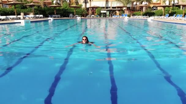 Hermosas mujeres nada en la piscina y disfruta del paisaje — Vídeos de Stock