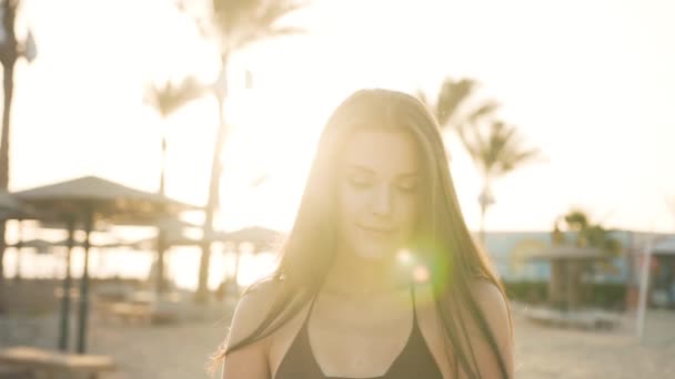 Beautiful girl near palms straightens her hair by the sea — Stock Video