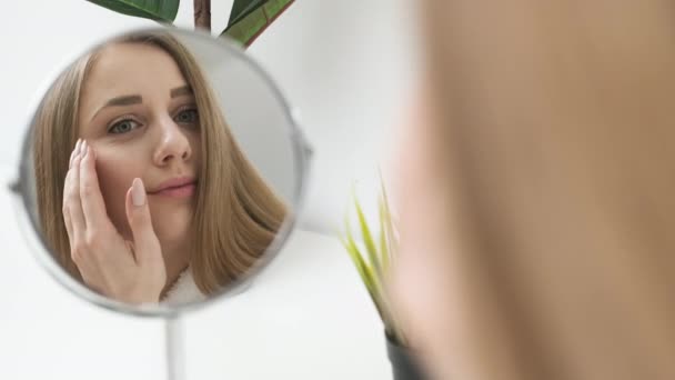 Portret van een leuke vrouw met een goed verzorgde huid in de spiegel — Stockvideo