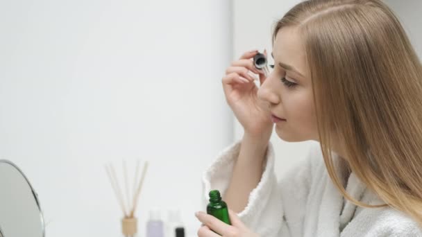 Linda linda chica aplica crema para el cuidado de la cara en los ojos — Vídeo de stock