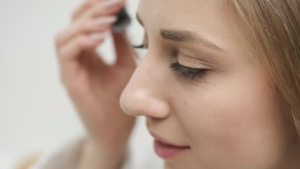 Linda linda chica aplica crema para el cuidado de la cara en los ojos — Vídeos de Stock