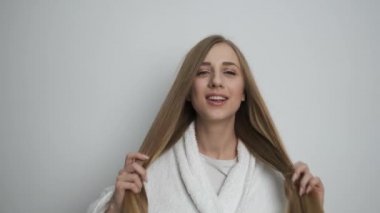 Kameranın önünde poz veren bornozlu güzel bir kız.