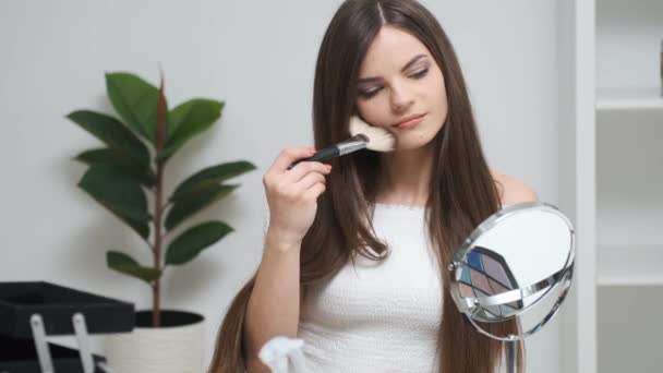 Chica haciendo maquillaje mirando en el espejo — Vídeo de stock