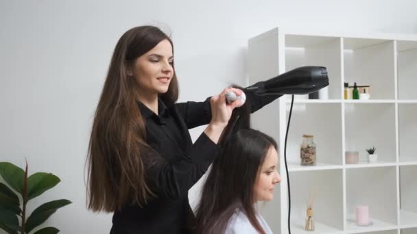 Chica alisando su cabello con rizador en un salón de belleza — Vídeos de Stock