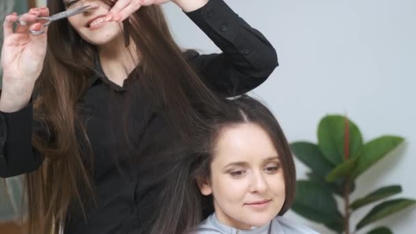 Chica cortándose el pelo en una peluquería — Vídeos de Stock